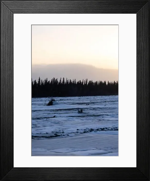 Framed Print : Snow on frozen river with trees and mountains in the background on the winter solstice in interior Alaska Framed Print : Snow on frozen river with trees and mountains in the background on the winter solstice in interior Alaska