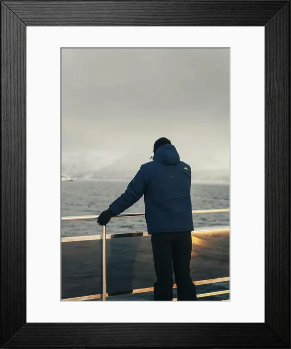 Framed Print : Man stood on edge of arctic tour boat looking at Lyngen Alps in winter in Norway Framed Print : Man stood on edge of arctic tour boat looking at Lyngen Alps in winter in Norway