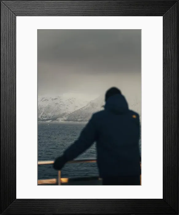 Framed Print : Arctic mountains under grey clouds beyond man on boat, the Lyngen Alps, Norway Framed Print : Arctic mountains under grey clouds beyond man on boat, the Lyngen Alps, Norway