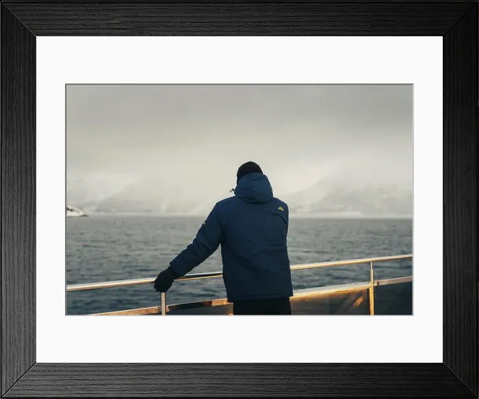 Framed Print : Man in blue coat stood on tour boat looking at misty Lyngen Alps in Norway Framed Print : Man in blue coat stood on tour boat looking at misty Lyngen Alps in Norway