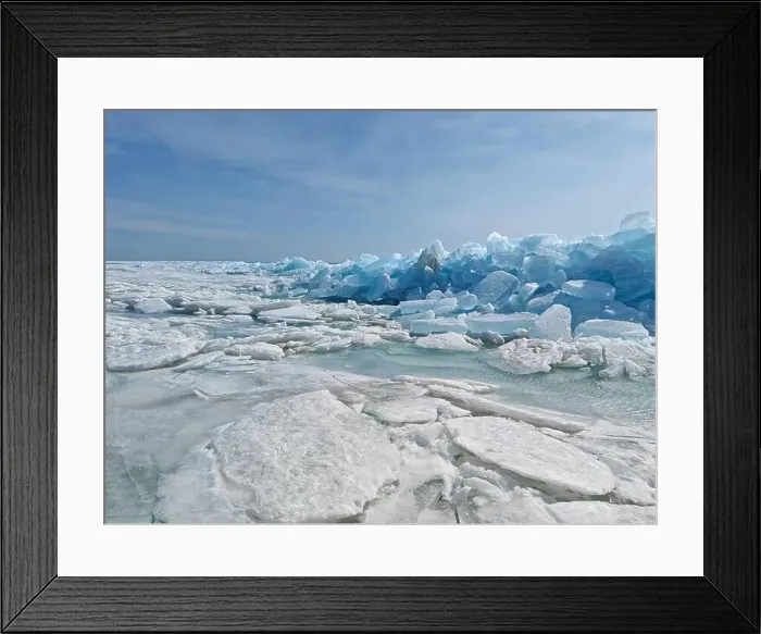 Framed Print : Ice chunks glisten under the sun, revealing stunning blue hues against a serene winter landscape by the lake