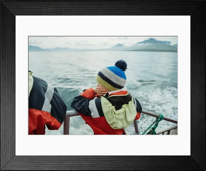 Framed Print : Boy on a boat watching for whales in the ocean in Dalvik, Iceland Framed Print : Boy on a boat watching for whales in the ocean in Dalvik, Iceland