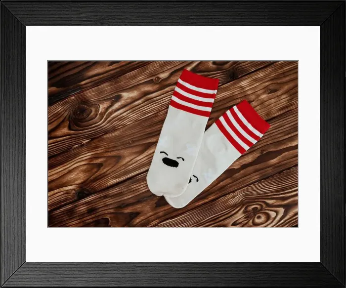 Framed Print : A pair of socks featuring a polar bear design are displayed against a white background Framed Print : A pair of socks featuring a polar bear design are displayed against a white background