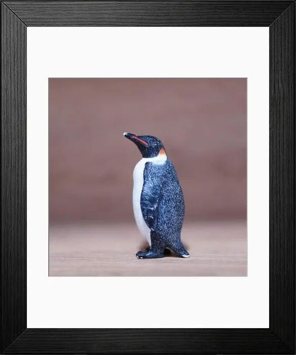 Framed Print : A closeup shot of a mini penguin toy figure on a wooden surface Framed Print : A closeup shot of a mini penguin toy figure on a wooden surface