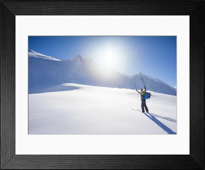 Framed Print : Skier lifts poles in the air, fully enjoying a blue bird winter day Framed Print : Skier lifts poles in the air, fully enjoying a blue bird winter day