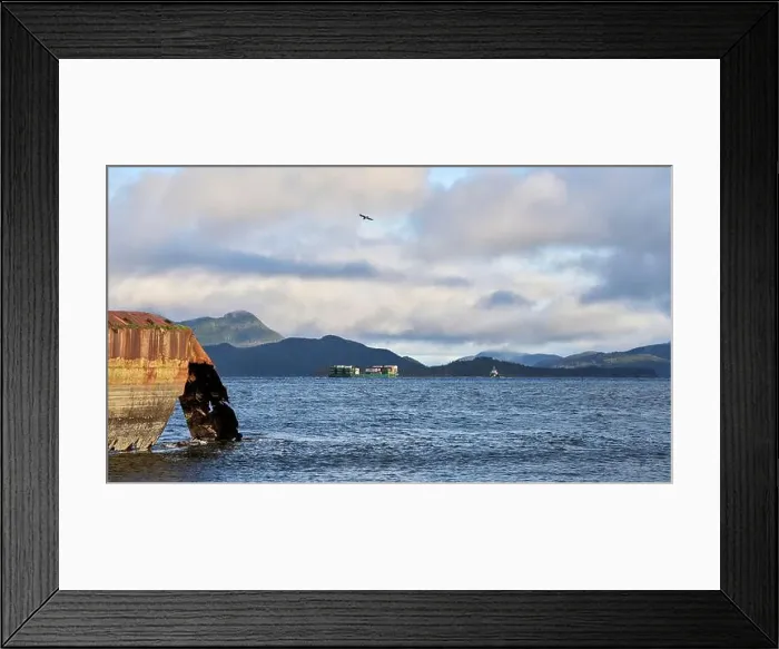 Framed Print : A distant tug and barge traveling down an ocean inlet with a rusted hull of an old ship in the foreground Framed Print : A distant tug and barge traveling down an ocean inlet with a rusted hull of an old ship in the foreground