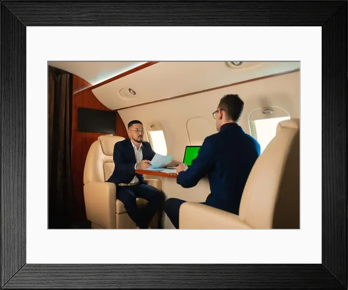 Framed Print : Two Businessman CEO couple in eyeglasses sitting inside a private jet airplane and talking about work shaking hands