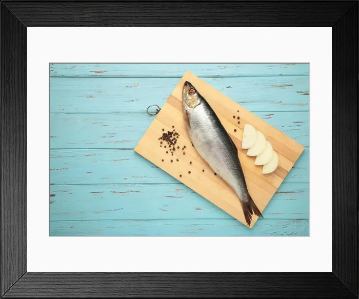 Framed Print : Fresh herring fish on cutting board on blue wooden background. Top view Framed Print : Fresh herring fish on cutting board on blue wooden background. Top view