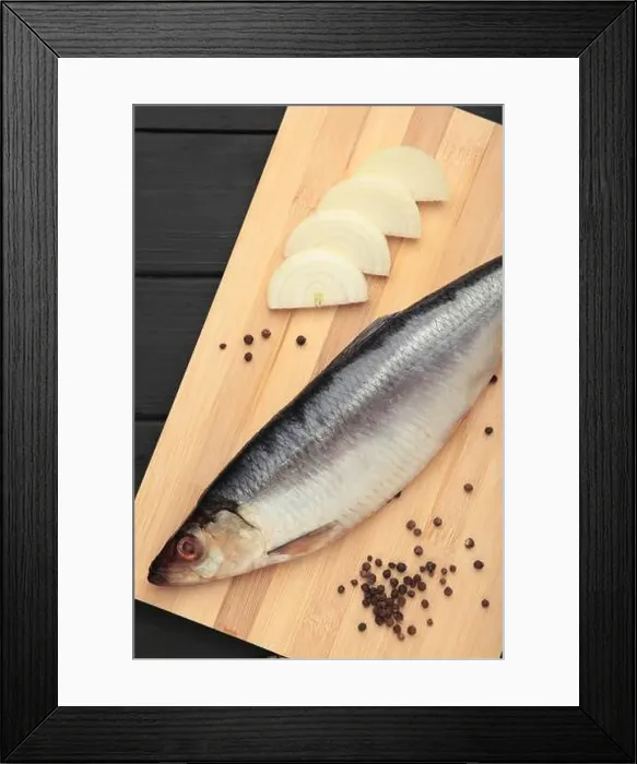 Framed Print : Fresh herring fish on cutting board on black wooden background. Top view Framed Print : Fresh herring fish on cutting board on black wooden background. Top view