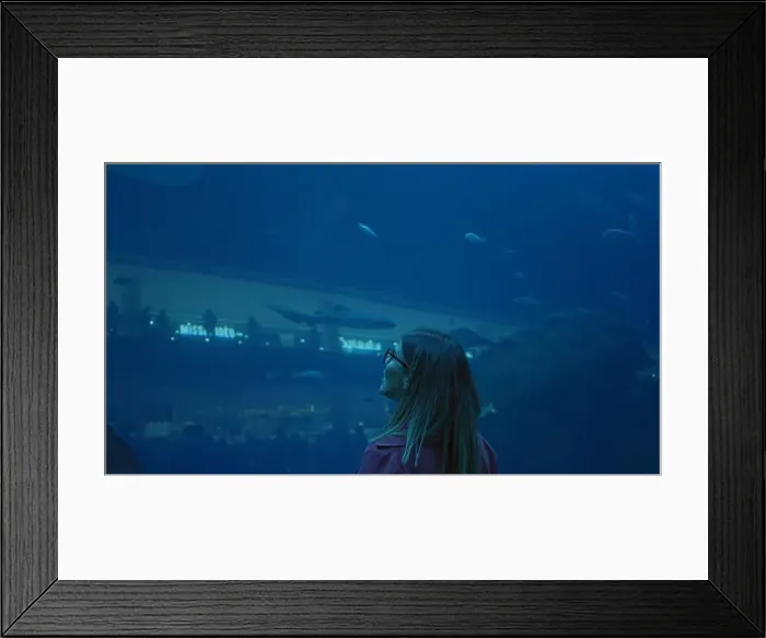 Framed Print : A brunette woman admires marine life at the dubai aquarium, reflecting travel and underwater tourism