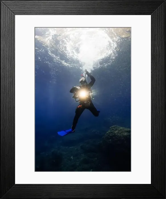 Framed Print : A male diver, equipped with a camera and lighting Framed Print : A male diver, equipped with a camera and lighting