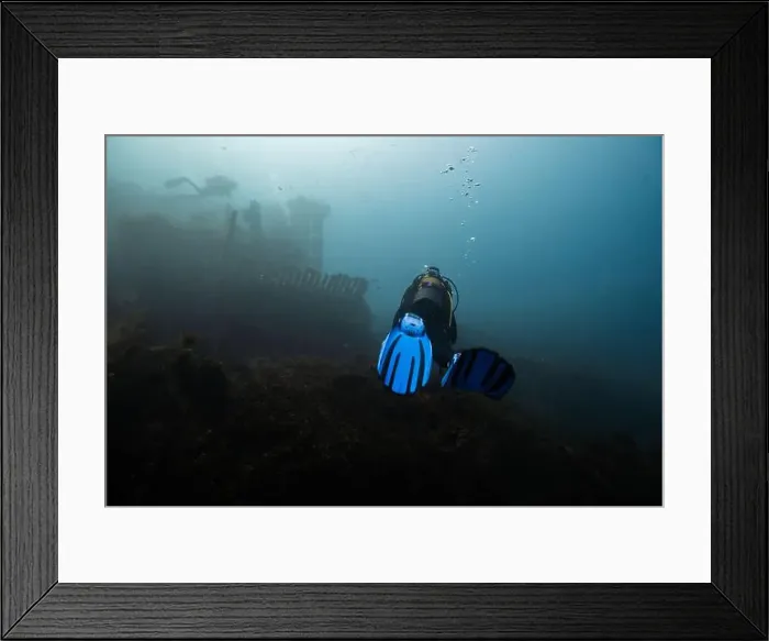 Framed Print : A scuba diver with blue fins investigates an eerie Framed Print : A scuba diver with blue fins investigates an eerie