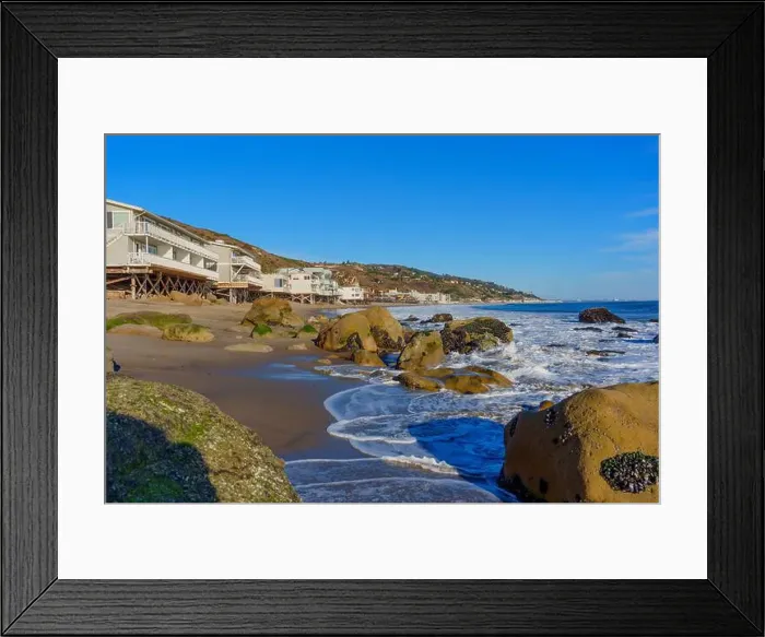 Framed Print : Gentle waves crashing on rocky shore at Malibu Beach with coastal homes in the backdrop Framed Print : Gentle waves crashing on rocky shore at Malibu Beach with coastal homes in the backdrop