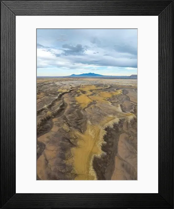 Framed Print : Aerial view of an expansive desert terrain featuring rugged formations and soft sand hues in Hanskville Framed Print : Aerial view of an expansive desert terrain featuring rugged formations and soft sand hues in Hanskville