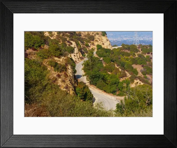 Framed Print : Detailed view of a curved road alongside hills in Griffith Park, showcasing the natural landscape and vegetation Framed Print : Detailed view of a curved road alongside hills in Griffith Park, showcasing the natural landscape and vegetation