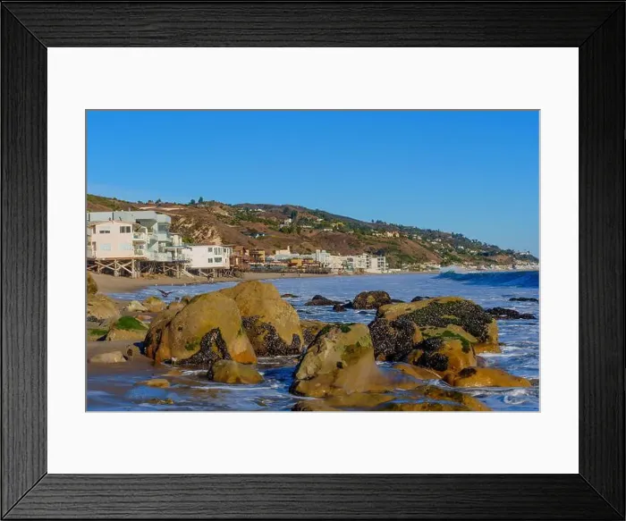 Framed Print : Rocky shoreline of Malibu Beach with cascading waves and coastal homes perched on the hillside Framed Print : Rocky shoreline of Malibu Beach with cascading waves and coastal homes perched on the hillside