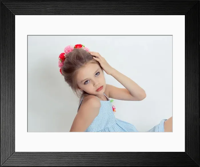 Framed Print : Closeup beautiful little girl wreath of flowers on head posing in studio hand on head isolated white grey background Framed Print : Closeup beautiful little girl wreath of flowers on head posing in studio hand on head isolated white grey background