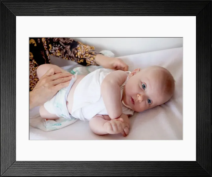 Framed Print : baby girl on the changing table, diaper change Framed Print : baby girl on the changing table, diaper change