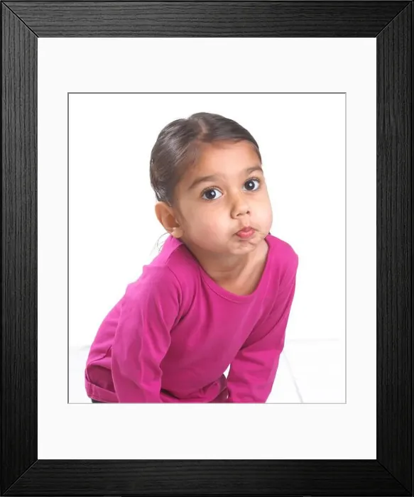Framed Print : Girl wearing pink top bending forward blowing a raspberry, 3.5 years Framed Print : Girl wearing pink top bending forward blowing a raspberry, 3.5 years