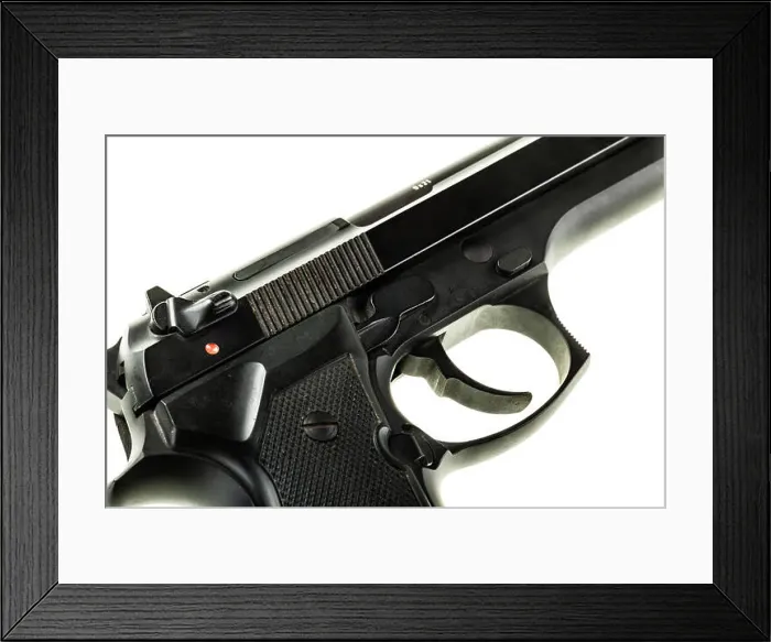 Framed Print : detail of a black 9mm pistol isolated over a white background Framed Print : detail of a black 9mm pistol isolated over a white background