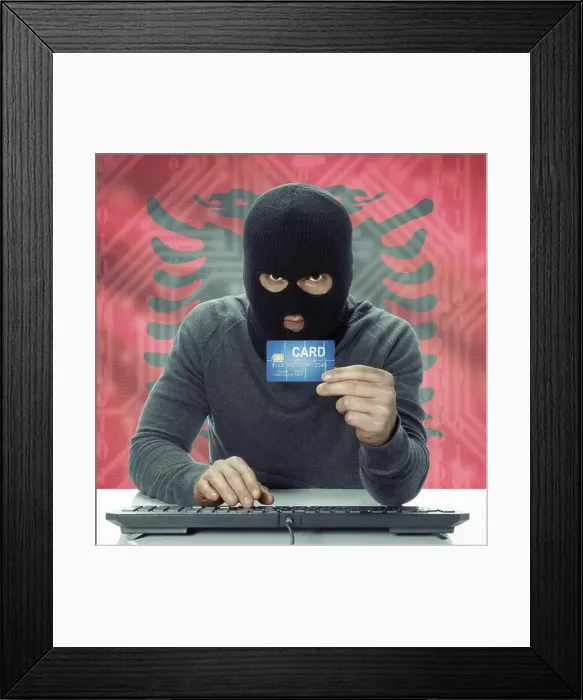 Framed Print : Dark-skinned hacker with credit card in hand and flag on background - Albania