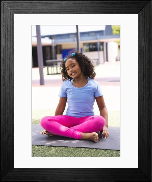 Framed Print : Biracial girl practices yoga outdoors at school Framed Print : Biracial girl practices yoga outdoors at school