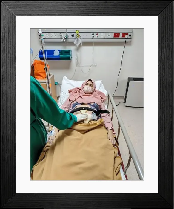 Framed Print : Patient laying on bed receiving medical treatment from nurse with green uniform in intensive care unit room at hospital Framed Print : Patient laying on bed receiving medical treatment from nurse with green uniform in intensive care unit room at hospital