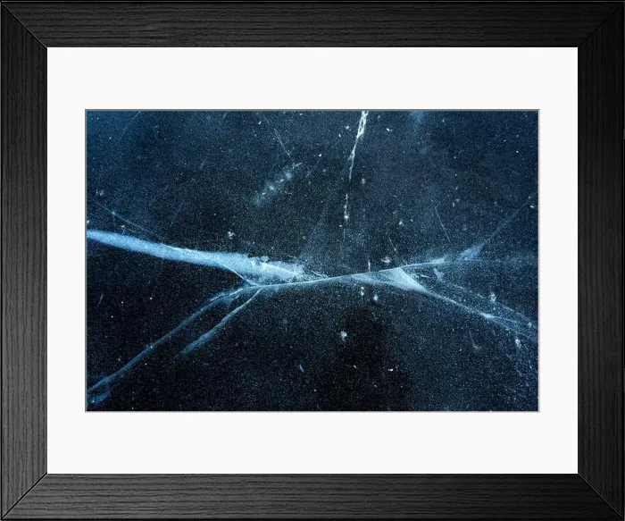 Framed Print : Close-up of cracked ice on lake surface. Long irregular white cracks on dark background. Natural background Framed Print : Close-up of cracked ice on lake surface. Long irregular white cracks on dark background. Natural background