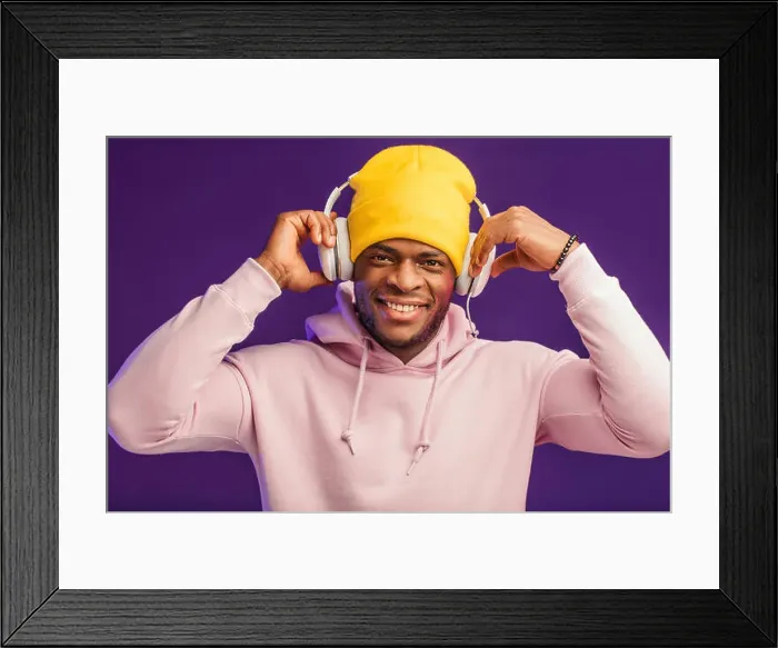 Framed Print : Joyful happy hipster man in white hoodie and yellow hat listening music with headphones Framed Print : Joyful happy hipster man in white hoodie and yellow hat listening music with headphones
