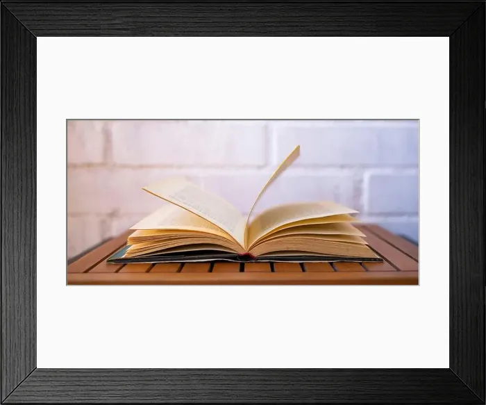 Framed Print : Open book turning the pages on a white background. Book and reading concept Framed Print : Open book turning the pages on a white background. Book and reading concept