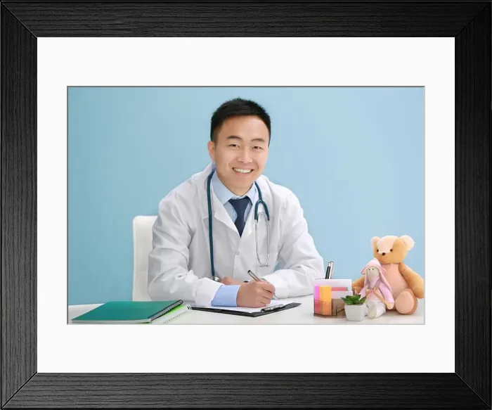 Framed Print : Handsome pediatrician doctor with teddy bear in office Framed Print : Handsome pediatrician doctor with teddy bear in office