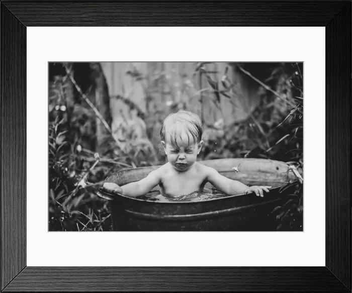 Framed Print : a little boy bathes in a basin in the summer in a green garden Framed Print : a little boy bathes in a basin in the summer in a green garden