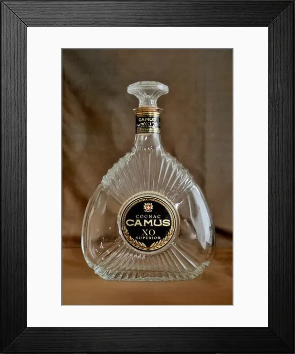Framed Print : An empty bottle of Cognac Camus XO Superior, displayed on the Brown background Framed Print : An empty bottle of Cognac Camus XO Superior, displayed on the Brown background