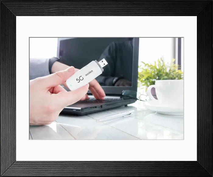 Framed Print : Man is holding modern 5G modem over office background Framed Print : Man is holding modern 5G modem over office background