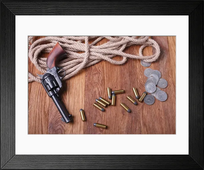 Framed Print : Wild west gun, ammunition and silver dollars on wooden table Framed Print : Wild west gun, ammunition and silver dollars on wooden table