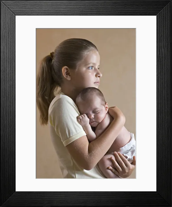 Framed Print : A young girl holding her baby sister closely Framed Print : A young girl holding her baby sister closely