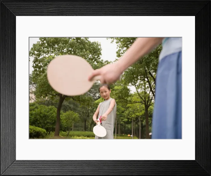 Framed Print : Girl playing tennis with her mother in a garden Framed Print : Girl playing tennis with her mother in a garden