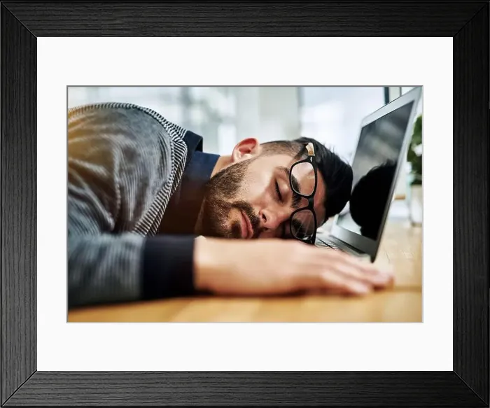 Framed Print : Hes ready to shutdown for the day. a young designer sleeping on his laptop while working in an office Framed Print : Hes ready to shutdown for the day. a young designer sleeping on his laptop while working in an office