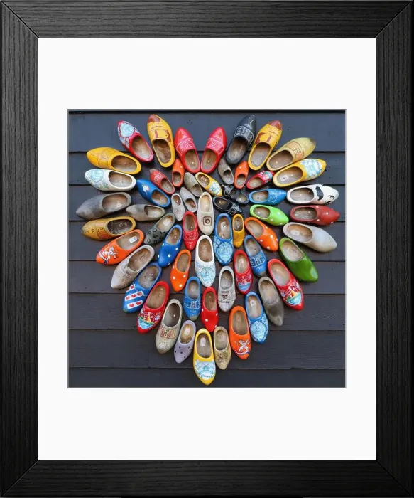 Framed Print : multicolored vintage dutch wooden shoes in shape of heart on black wood panel background Framed Print : multicolored vintage dutch wooden shoes in shape of heart on black wood panel background