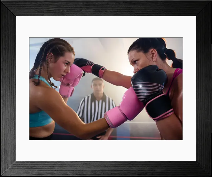 Framed Print : Female boxers punching each other at boxing ring at fitness studio