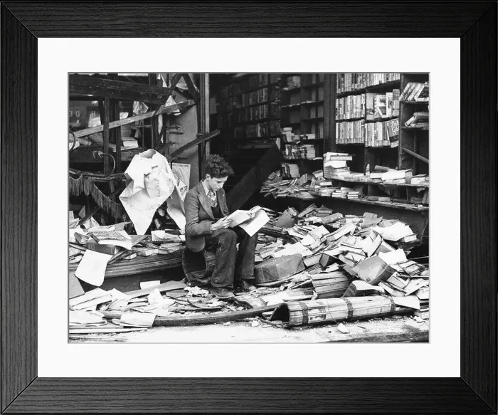 Framed Print : A young boy sat reading outside the ruins of a London bookshop after an air raid during the Blitz, London 1940 Framed Print : A young boy sat reading outside the ruins of a London bookshop after an air raid during the Blitz, London 1940