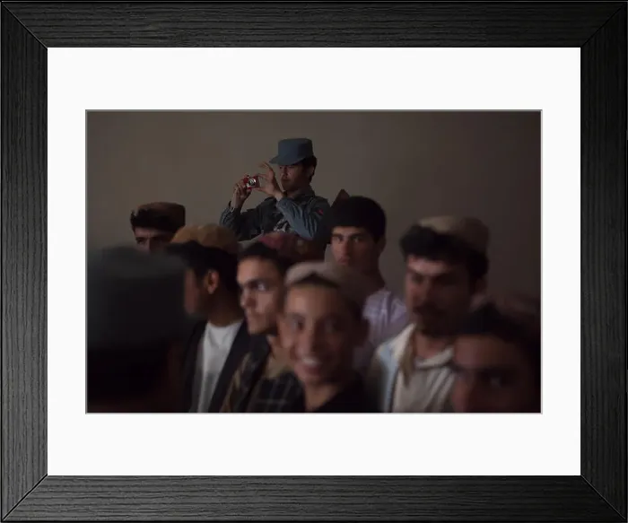Framed Print : A member of the Afghan Uniformed Police takes a photo of students waiting to receive donated books Framed Print : A member of the Afghan Uniformed Police takes a photo of students waiting to receive donated books