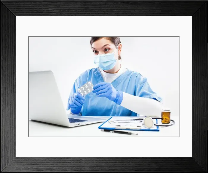 Framed Print : Woman GP doctor holding medicine prescribing patient therapy during online virtual appointment over laptop computer Framed Print : Woman GP doctor holding medicine prescribing patient therapy during online virtual appointment over laptop computer