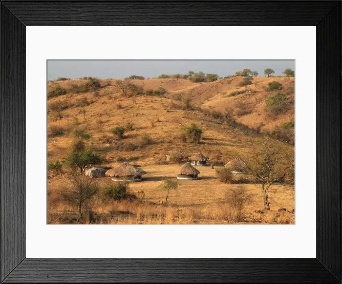 Framed Print : A traditional poor African village in Uganda made of earthenware round huts and thatched roofs Framed Print : A traditional poor African village in Uganda made of earthenware round huts and thatched roofs