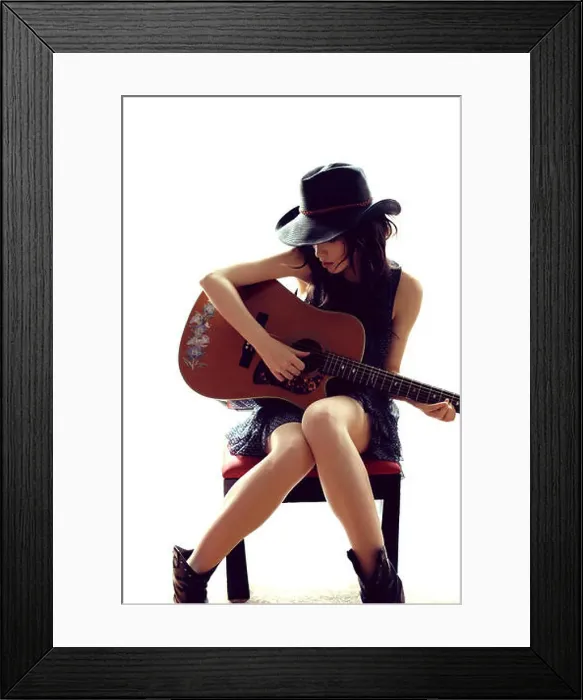 Framed Print : Brunette woman sitting, playing guitar Framed Print : Brunette woman sitting, playing guitar