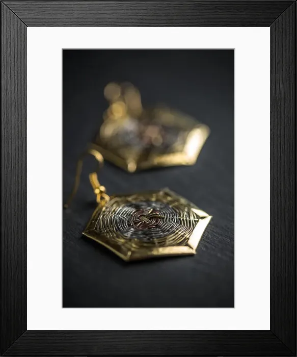 Framed Print : Hexagonal metal earring on black background Framed Print : Hexagonal metal earring on black background