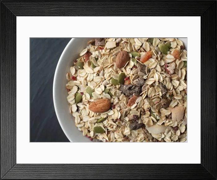 Framed Print : Breakfast oat muesli with nuts, seeds and dried fruits in a white bowl on dark background Framed Print : Breakfast oat muesli with nuts, seeds and dried fruits in a white bowl on dark background