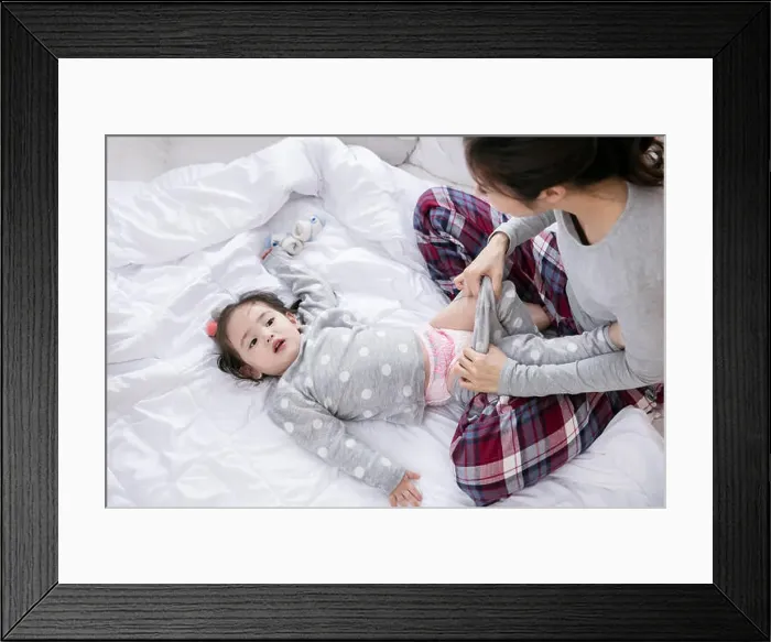 Framed Print : Loving mother taking care of daughter in multicultural family