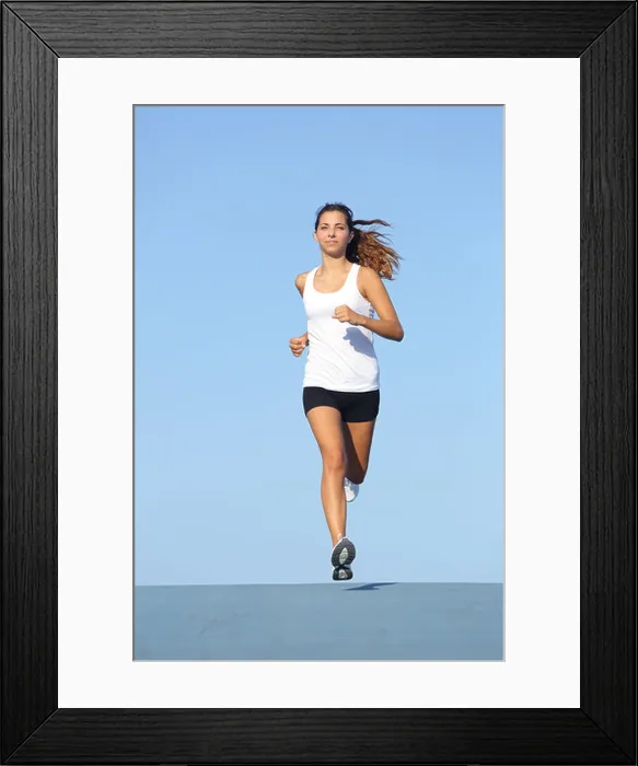 Framed Print : Front view of a beautiful sportswoman running towards camera with the blue sky in the background Framed Print : Front view of a beautiful sportswoman running towards camera with the blue sky in the background