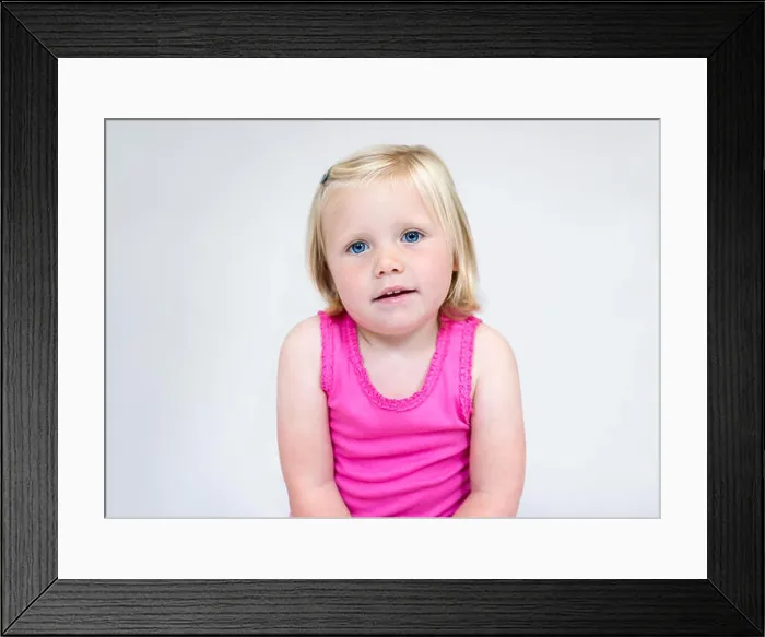 Framed Print : Portrait of a young girl with short blonde hair and blue eyes wearing a pink vest smiling Framed Print : Portrait of a young girl with short blonde hair and blue eyes wearing a pink vest smiling